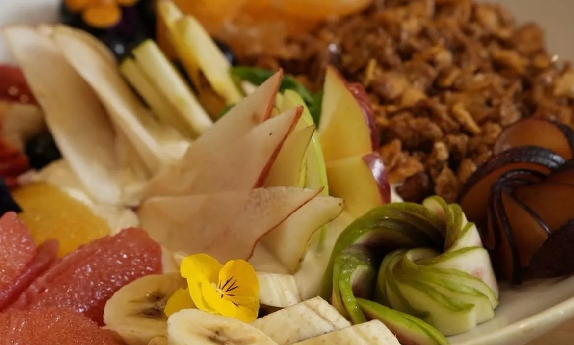 Ensalada de frutas con cítricos, manzana, pera, banana y granola en Merienda